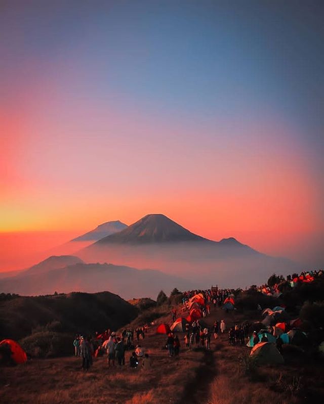 Golden hour di Gunung Prau dengan siluet pegunungan sekitar