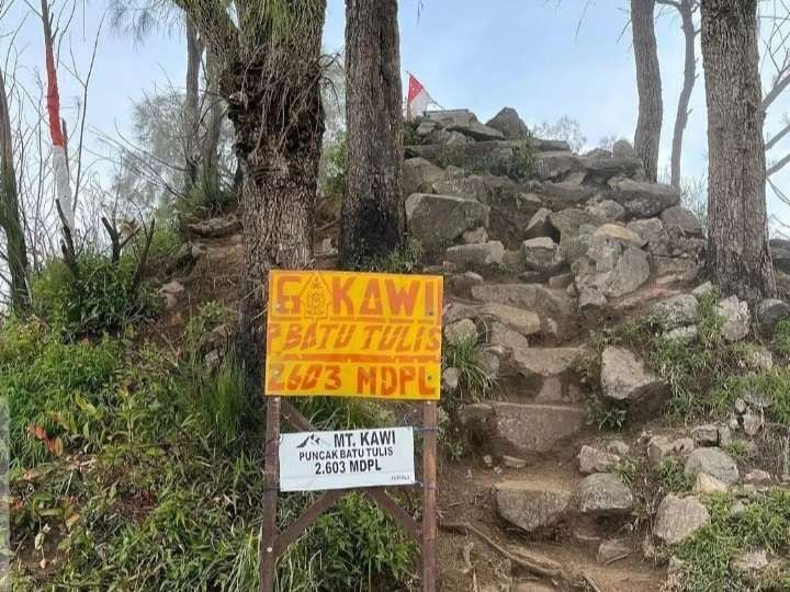 Pemandangan sunrise dari puncak Gunung Kawi dengan siluet pegunungan Jawa Timur