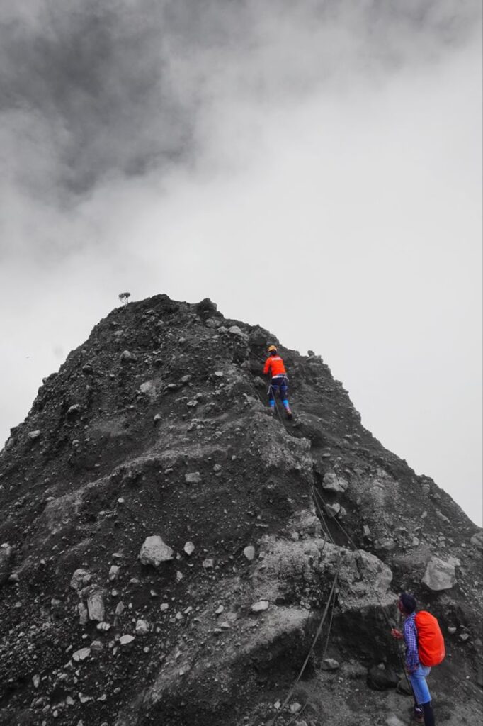 Pendaki mencapai Puncak Sejati Gunung Raung via Kalibaru, panorama kaldera kering terlihat jelas.