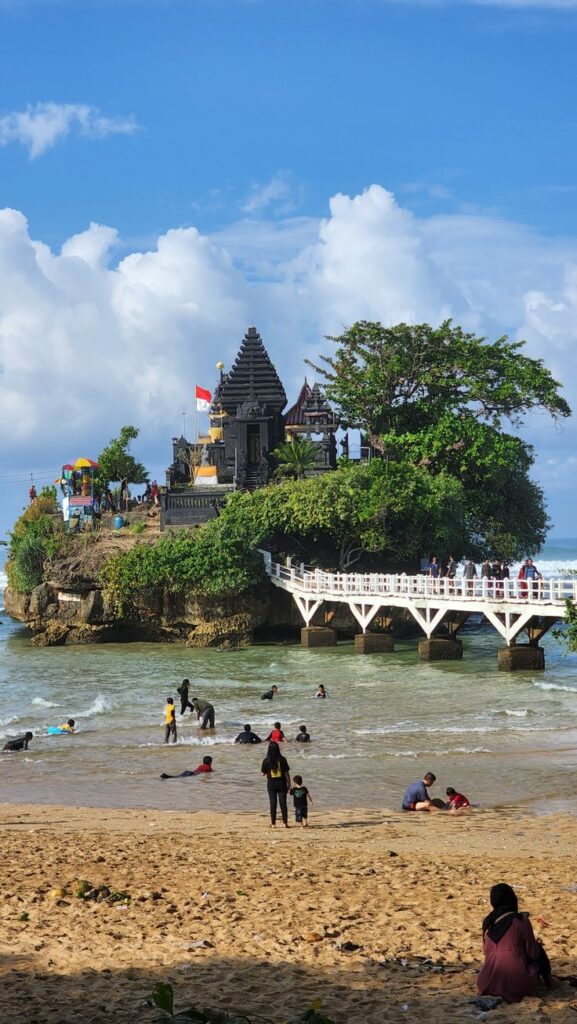 Hamparan pasir putih panjang di Pantai Balekambang Malang dengan panorama laut biru dan ombak khas pantai selatan