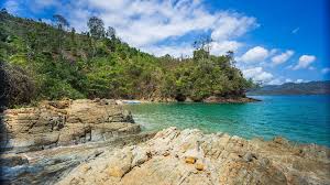Suasana sepi Pantai Bolu-Bolu dengan pasir cokelat halus dan gradasi air laut biru