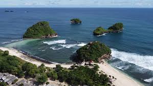 Panorama Pantai Goa Cina dengan pasir putih dan ombak besar bertemu dari tiga arah